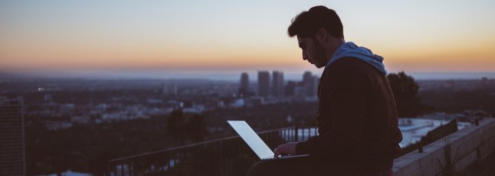 Man with laptop at sunset