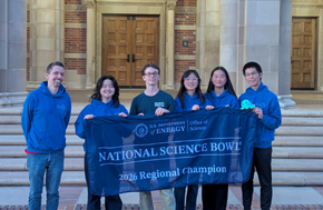 Uni's science bowl team posing with championship banner in front of UCLA building