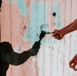 person painting a fence
