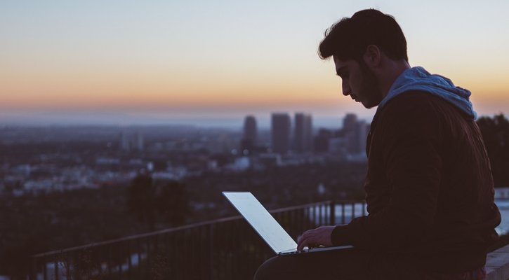 Man with laptop at sunset